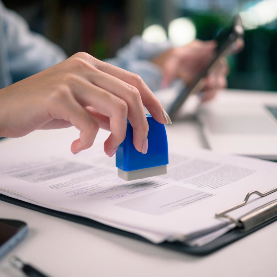 close-up of hand stamping a contract clipboard. contracts, and the final stages of a business agreement or legal process. official approval, and administrative efficiency.